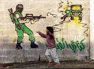 A Palestinian boy passes graffiti of a Hamas gunman in the Gaza strip